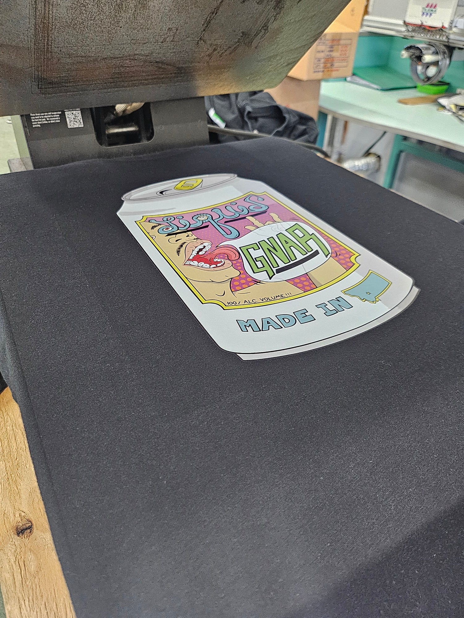 Customized Shirt on heat press with a brightly colored DTF Logo